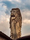 A majestic Merlion statue on Sentosa Island, Singapore with dark dramatic clouds. The Merlion is a mythical creature and the