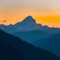 Majestic mountain peak silhouette backlit by yellow sunrise