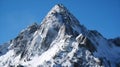 A rugged snow-covered mountain peak standing tall against a clear blue sky created with Generative AI