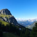 Majestic mountain range with a clear blue sky overlooking a lush valley and a small mountain hut Royalty Free Stock Photo