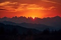 majestic mountain range, with fiery sunset in the background and silhouettes of peaks Royalty Free Stock Photo