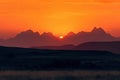 majestic mountain range, with fiery sunset in the background and silhouettes of peaks Royalty Free Stock Photo