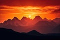 majestic mountain range, with fiery sunset in the background and silhouettes of peaks Royalty Free Stock Photo