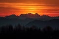 majestic mountain range, with fiery sunset in the background and silhouettes of peaks in view Royalty Free Stock Photo