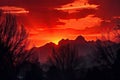 majestic mountain range, with fiery sunset in the background, and silhouettes of trees against the sky Royalty Free Stock Photo