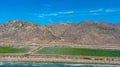 Majestic mountain ranges along the coast with lush green farmland and freeways with cars and blue sky with clouds at Rincon Beach Royalty Free Stock Photo