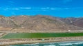 Majestic mountain ranges along the coast with lush green farmland and freeways with cars and blue sky with clouds at Rincon Beach Royalty Free Stock Photo