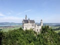 The majestic Neuschwanstein Castle in Bavaria on a sunny, windless day.
