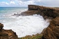 a very big rocky ocean cave with water coming out of it Royalty Free Stock Photo