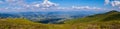 A majestic panorama of green mountain peaks stretching to the horizon line