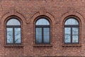a large red brick building with three windows and trees in the window Royalty Free Stock Photo