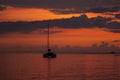 Majestic saturated sea landscape - colorful sunset in ocean with golden sky, dark clouds, reflections in calm water, sunbeam. Royalty Free Stock Photo