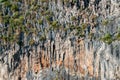 Majestic sheer textured colorful mountain covered of limestone with tropical greenery wall. Big orange cliff