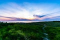 Majestic shot of a beautiful sunset over the northern sea near Emden taken from a fresh green field Royalty Free Stock Photo