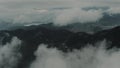 Majestic shot of a forested mountain range surrounded by low flying clouds Royalty Free Stock Photo