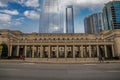 A majestic shot of the glass skyscrapers office buildings in the cityscape with a brown stone building with tall pillars