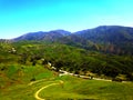 a majestic shot of the lush green hillsides and mountains with a long winding road