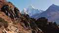 Majestic snow-capped mountain Ama Dablam with hiking trail and stone steps in foreground in the Himalayas near Phortse.