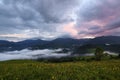 Majestic spring day. A beautiful landscape with high mountains, sky with clouds and sunset. Dense fog with beautiful light.