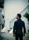 The Majestic Staircase: A Man's Solemn Pose at the Foot of a Grand, Ascending Path