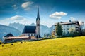 Majestic summer scene of Pfarramt Catholic Church with Bischofsmutze mountain range on background. Dramatic morning view of the