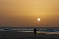 Majestic sunrise with a lonely man on a sand long beach on a Canary island in the Atlantic ocean Fuerteventura