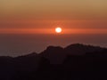 Majestic sunset above the Atlantic Ocean with red sun in the colorful dramatic sky viewed from Roque Nublo, Canary Islands, Spain. Royalty Free Stock Photo