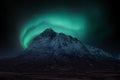 Majestic vibrant Northern Lights Aurora composite image over landscape of snowcapped mountain in Scottish Highlands