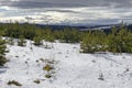 Majestic view of cloudy sky, winter mountain, snowy glade, conifer and deciduous forest from Plana mountain toward Rila mountain Royalty Free Stock Photo
