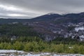 Majestic view of cloudy sky, winter mountain, snowy glade, residential district, conifer and deciduous forest from Plana mountain Royalty Free Stock Photo