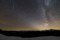 Majestic view of fantastic starry dark sky on winter night. Milky Way and falling star over magnificent mountain ridge snow-capped Royalty Free Stock Photo