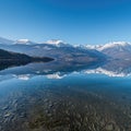 Majestic view of snow mountains peaks reflecting in lake