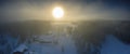 Majestic view of winter sunset with very large sun spot in frozen foggy air, winter pine tree forest, aerial, Grano village,