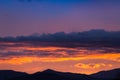 Majestic vivid sunset/sunrise with clouds over dark mountains Royalty Free Stock Photo