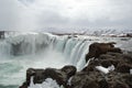 Majestic waterfall cascading over a rocky bed, with a few snow-covered rocks on either side, Iceland Royalty Free Stock Photo