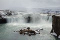 Majestic waterfall cascading over a rocky bed, with a few snow-covered rocks on either side, Iceland Royalty Free Stock Photo