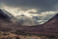 Majestic Winter landscape image of Etive Mor in Scottish Highlands with sunbeams streaming down between the mountain peaks Royalty Free Stock Photo