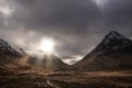 Majestic Winter landscape image of Etive Mor in Scottish Highlands with sunbeams streaming down between the mountain peaks Royalty Free Stock Photo