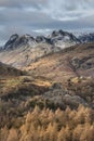 Majestic Winter landscape image view from Holme Fell in Lake District towards snow capped mountain ranges in distance in glorious