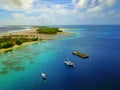 Aerial view of a beautiful atoll with village and moored yachts