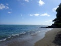 Makalei Beach with waves lapping, napakaa, lava rock wall and Coconut trees along the shore Royalty Free Stock Photo