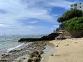 Makalei Beach with waves lapping, napakaa, and a lava rock wall that jetty into the ocean Royalty Free Stock Photo