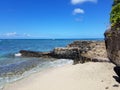 Makalei Beach with waves lapping, napakaa, and a lava rock wall that jetty into the ocean Royalty Free Stock Photo