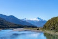 Makarora River flows over wider river bed between bush-clad South Alps mountains