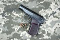 Makarov pistol with cartridges on the background of military camouflage pixel. Royalty Free Stock Photo