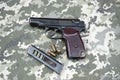 Makarov pistol with cartridges on the background of military camouflage pixel. Royalty Free Stock Photo