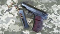 Makarov pistol with cartridges on the background of military camouflage pixel. Royalty Free Stock Photo