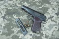 Makarov pistol with cartridges on the background of military camouflage pixel. Royalty Free Stock Photo