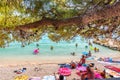 Makarska, Croatia - 22.7.2021: Peoples on the beach at Makarska city, Croatia. Pine tree in foreground, relaxation on the beach, Royalty Free Stock Photo