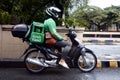 Motorcycle food delivery driver wait at an intersection for the stoplight to turn green